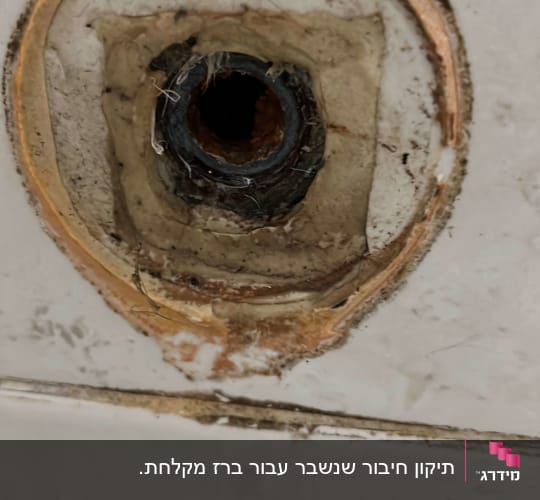 חיבור צינור מים בקיר עם סימני חלודה